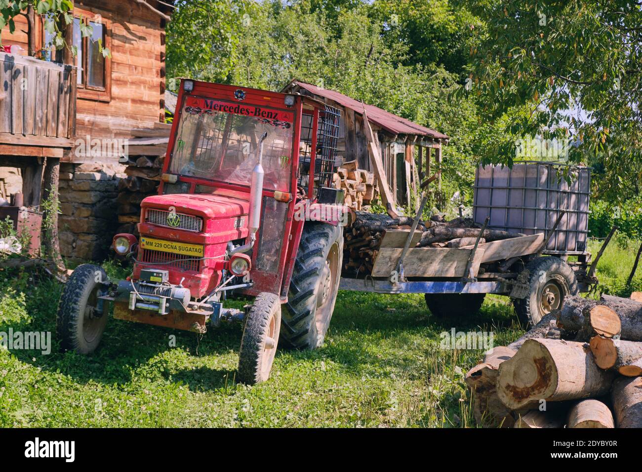 Alte rote Traktor und Anhänger auf einem Bauernhof von Breb, in der Region Maramures in Rumänien, wo die Menschen noch eine einfachere Art und Weise leben Stockfoto