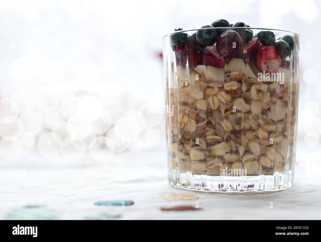 Frühstück, Essen, gesunde Ernährung und Diät-Konzept - schließen Sie ein Glas Müsli Haferflocken mit Chia, Cranberry und amerikanische Heidelbeeren auf dem Tisch Stockfoto