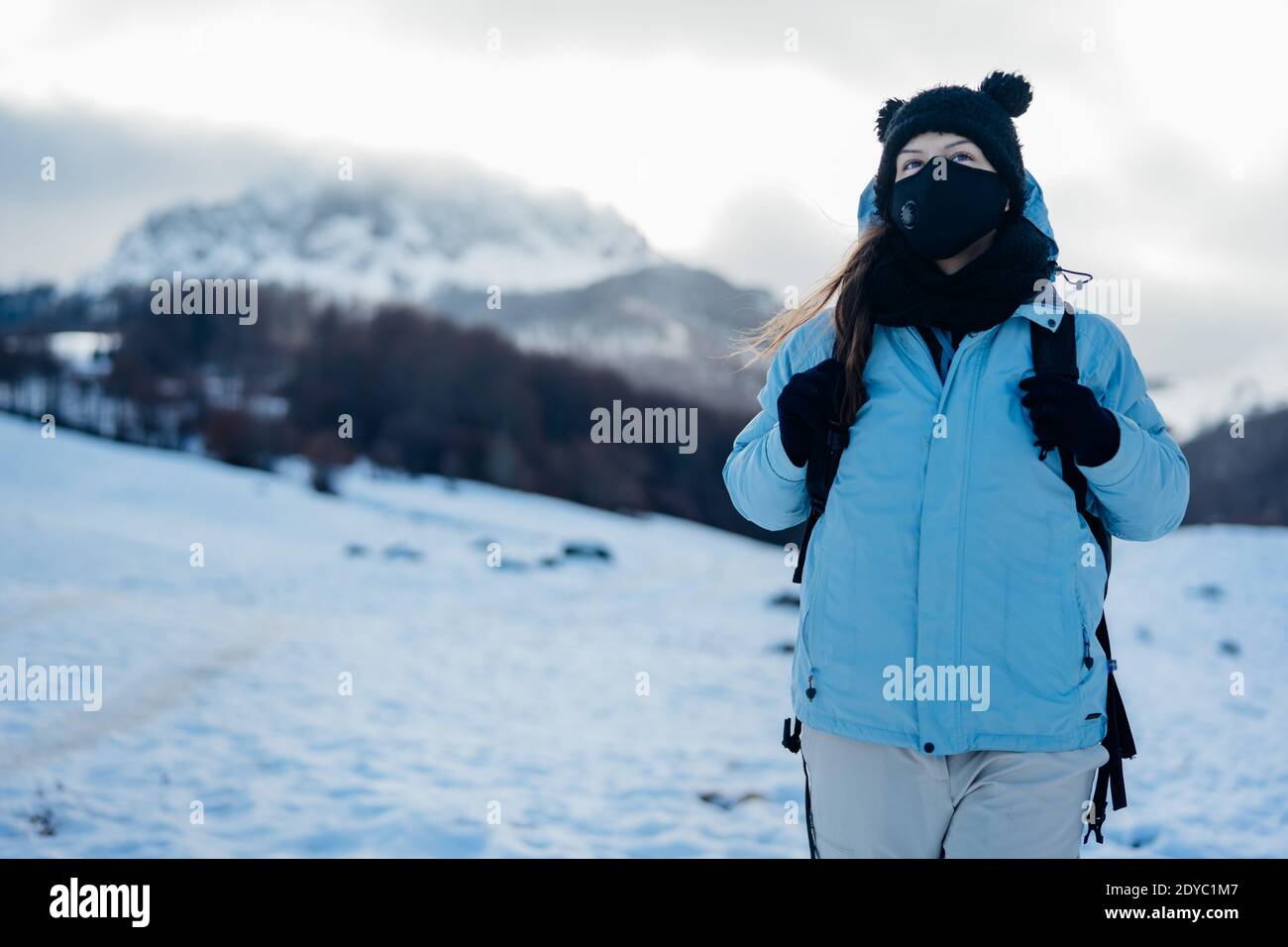 Weibliche Tourist trägt eine Schutzmaske in der Natur auf dem Berg Urlaub.Aktivurlaub während der Pandemie.natürliche Schönheit.Wanderer auf einen Winter t Stockfoto