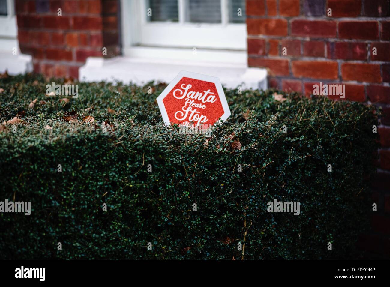 'Santa bitte aufhören'. Ein Schild, das außerhalb eines Hauses angezeigt wird. Weihnachtsschilder. Stockfoto