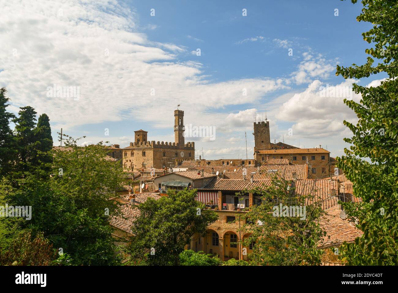 Blick auf die Dächer der etruskischen Stadt Volterra mit dem Palazzo dei Priori gegen klaren blauen Himmel im Sommer, Pisa, Toskana, Italien Stockfoto