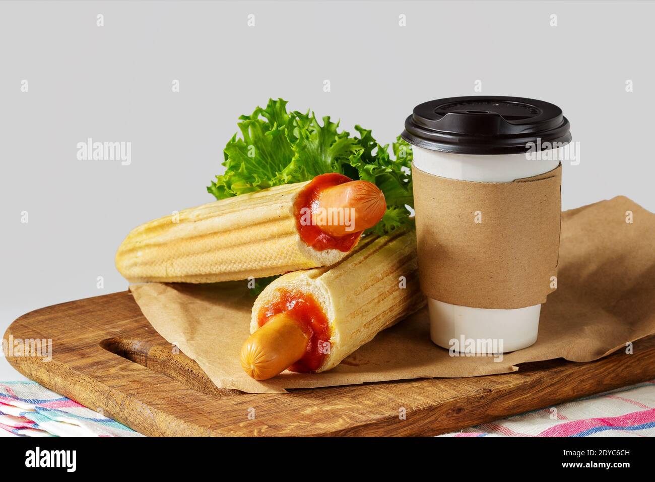 Französische Hot Dog und Kaffee auf Holz Schneidebrett über grauen Hintergrund zu gehen. Fast Food essen Menü Stockfoto