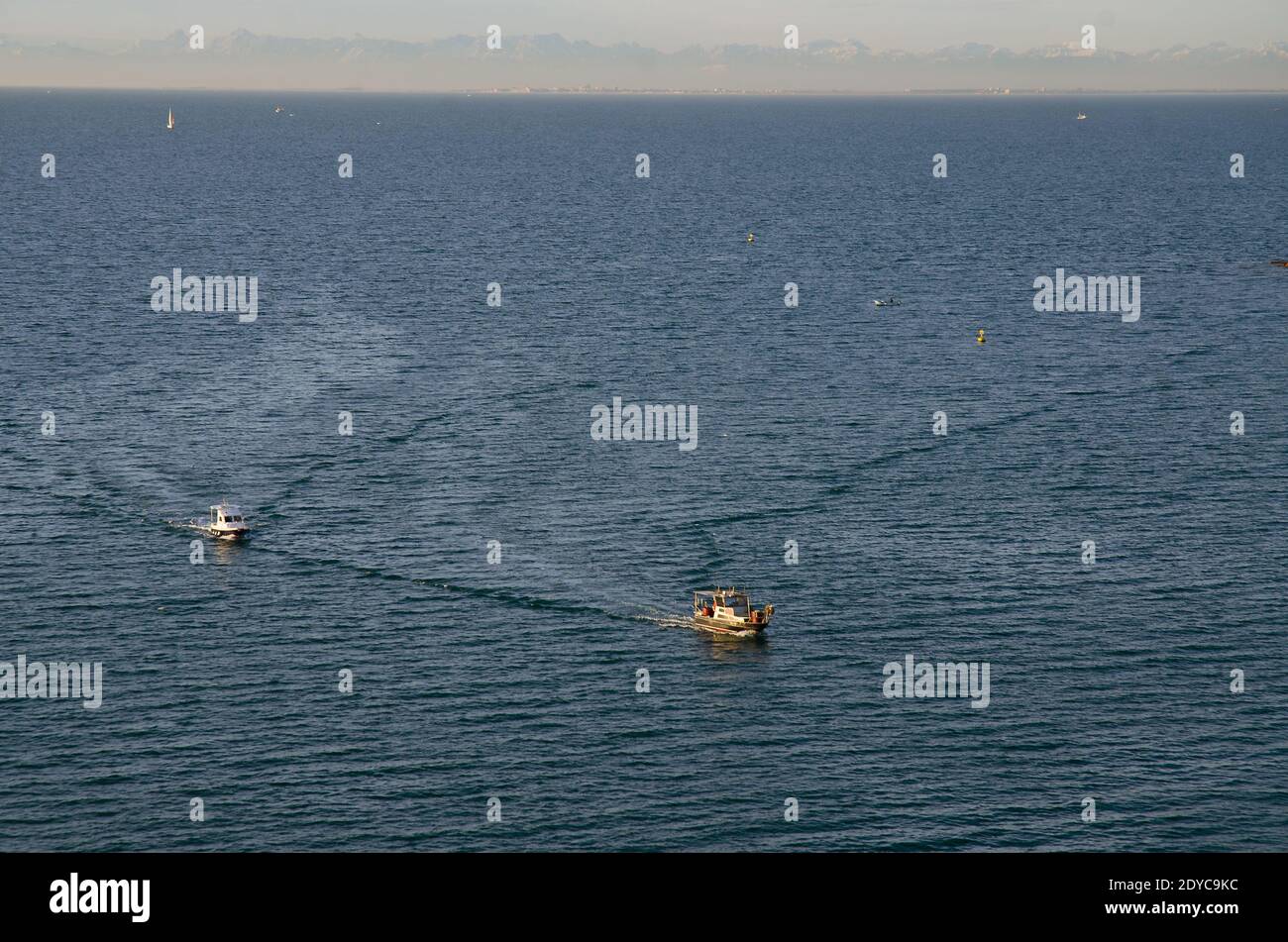 Hintergrund von herrlichem Blick auf die mehrere Boote segeln entlang Adria blauen Meer gegen schneebedeckten alpen Berge. Stockfoto