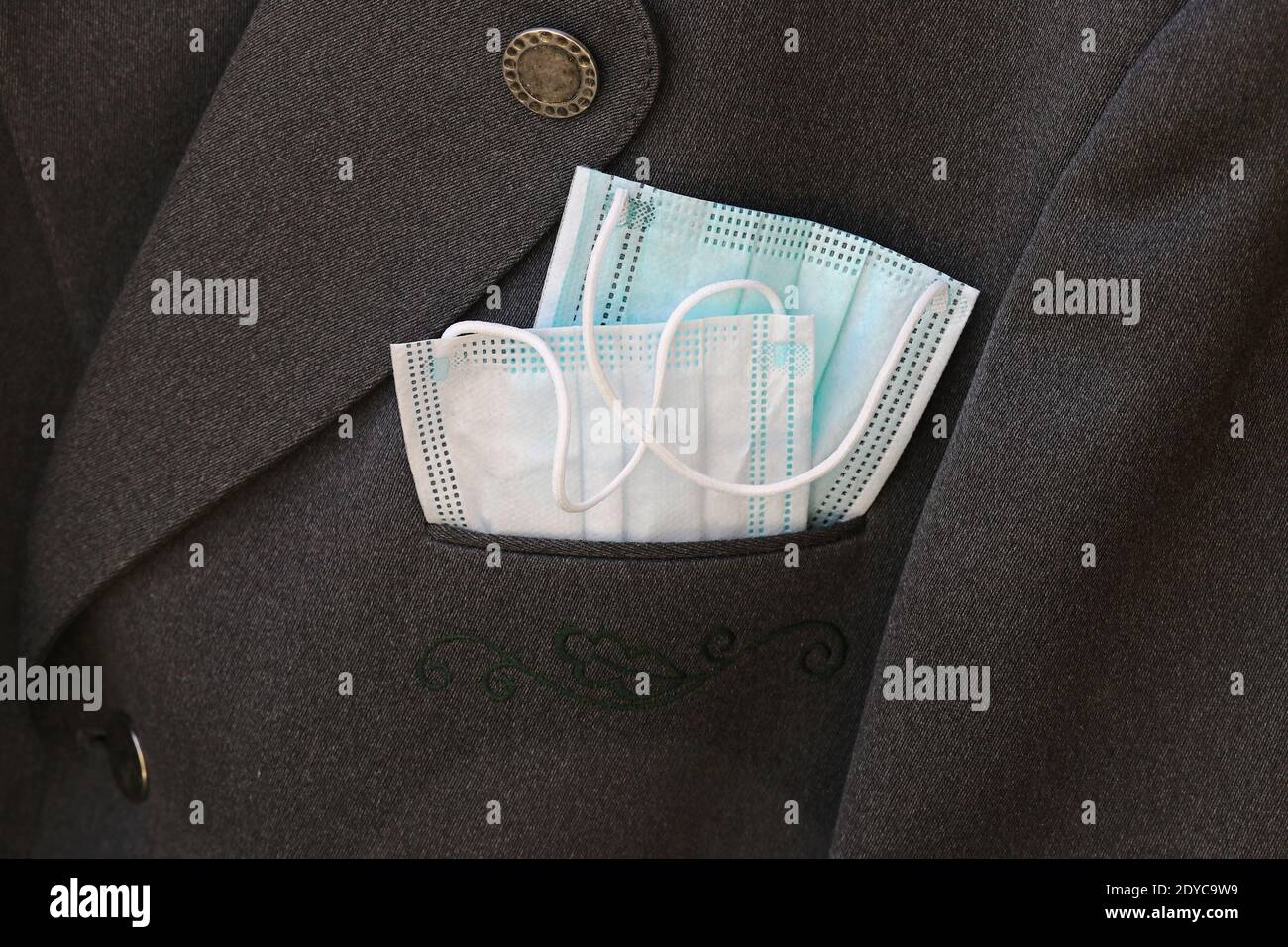 Es gibt zwei Coronamasken in einem Anzug. Schutzmasken im Alltag Stockfoto