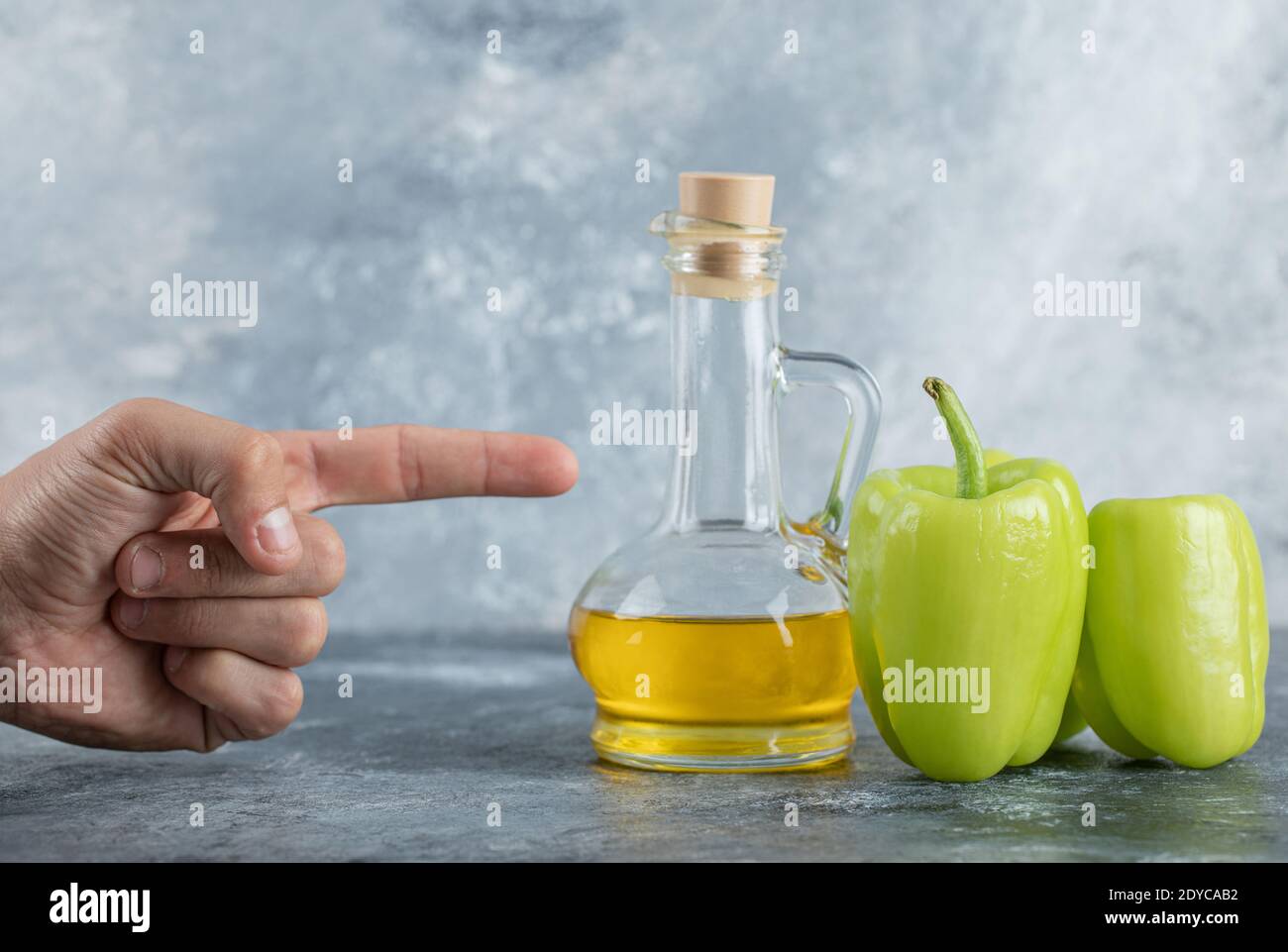 Mann zeigen Finger auf das Öl und süßen grünen Pfeffer Stockfoto