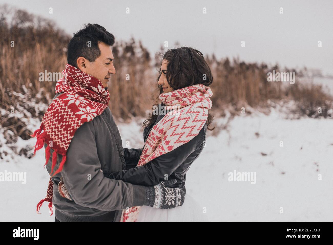 Braut und Bräutigam in Liebe Paar in gestrickten Schal und Fäustlinge im Winter mit Schnee Stockfoto