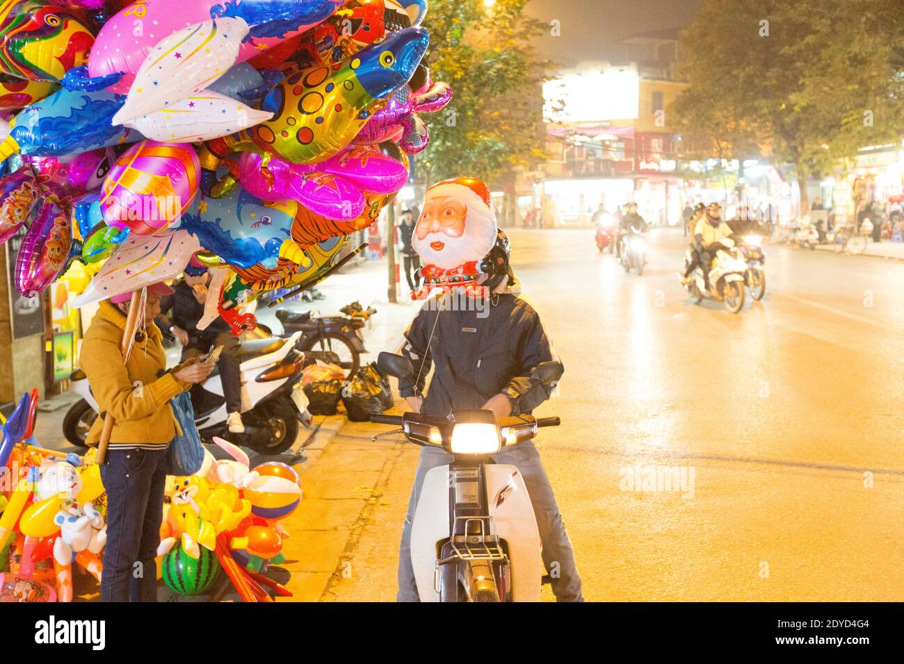 Vietnam Hanoi Ballon-Händler auf einer belebten Straße in der Nacht Stockfoto
