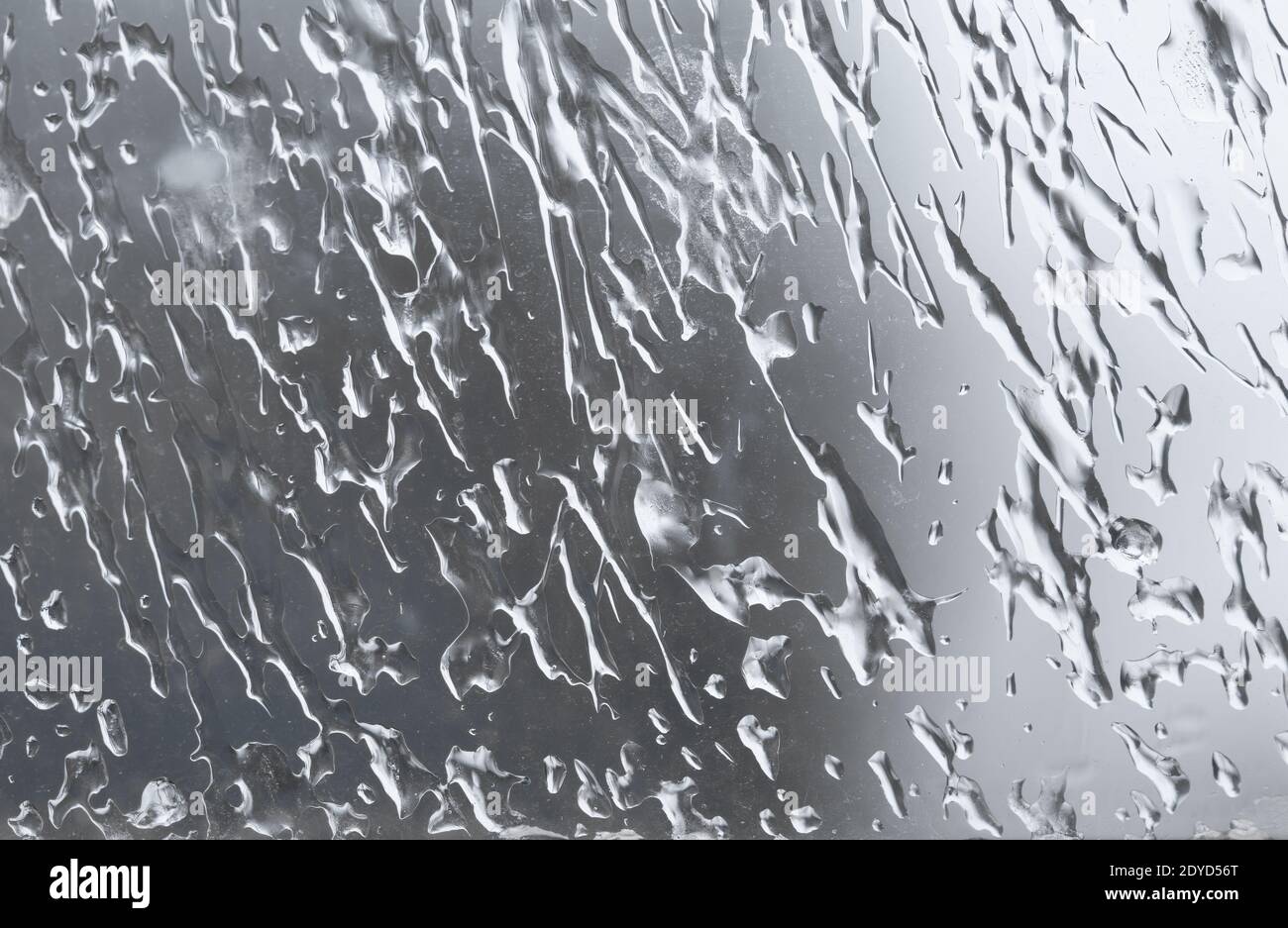 Tropfen gefrorenen Wassers auf einem Fensterglas im Winter Stockfoto