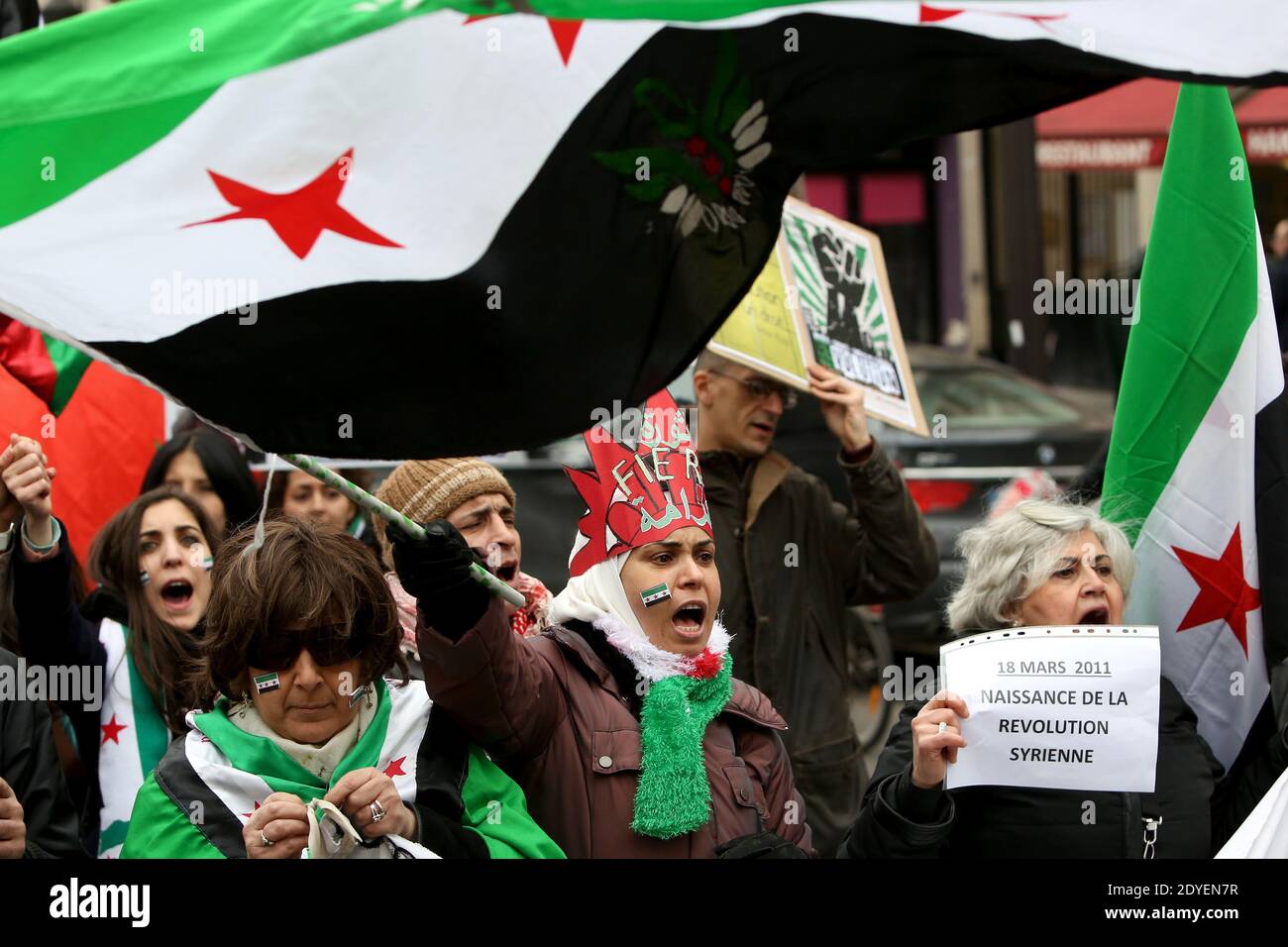 Demonstranten schwenken am 16. März 2013 anlässlich des 2. Jahrestages des Konflikts in Syrien auf einer Demonstration in Paris Unabhängigkeitsfahnen und Schilder. Zwei Jahre später ist Syrien in einem Bürgerkrieg verstrickt, der mindestens 70,000 Menschenleben gekostet hat und eine Million Menschen zur Flucht ins Ausland gezwungen hat, Millionen weitere vermisste oder vertriebene Menschen, was eine wirtschaftliche und humanitäre Katastrophe auslöste. Foto von Stephane Lemouton/ABACAPRESS.COM Stockfoto