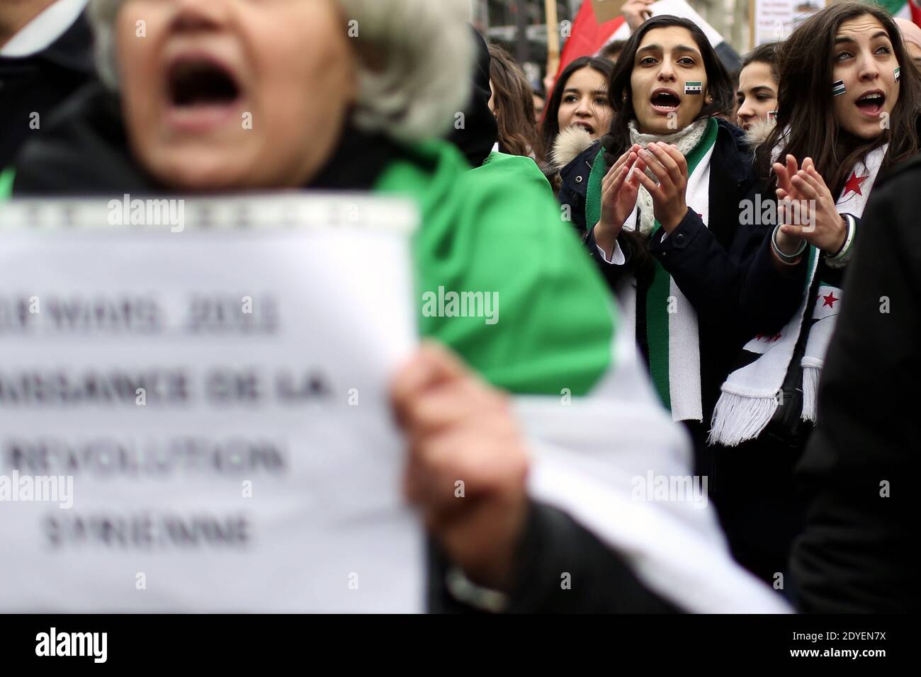 Demonstranten schwenken am 16. März 2013 anlässlich des 2. Jahrestages des Konflikts in Syrien auf einer Demonstration in Paris Unabhängigkeitsfahnen und Schilder. Zwei Jahre später ist Syrien in einem Bürgerkrieg verstrickt, der mindestens 70,000 Menschenleben gekostet hat und eine Million Menschen zur Flucht ins Ausland gezwungen hat, Millionen weitere vermisste oder vertriebene Menschen, was eine wirtschaftliche und humanitäre Katastrophe auslöste. Foto von Stephane Lemouton/ABACAPRESS.COM Stockfoto