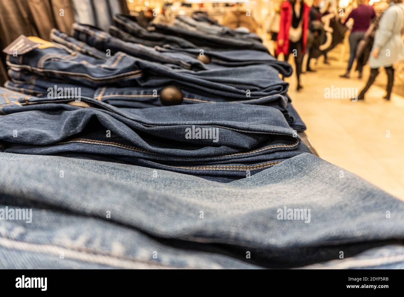 Ein Stapel Denim-Hosen in einem Einkaufszentrum liegt in Zeilen Stockfoto