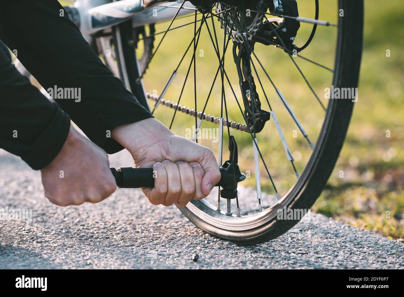 Nahaufnahme eines Mannes, der das Rad auf der Straße pumpt Stockfoto