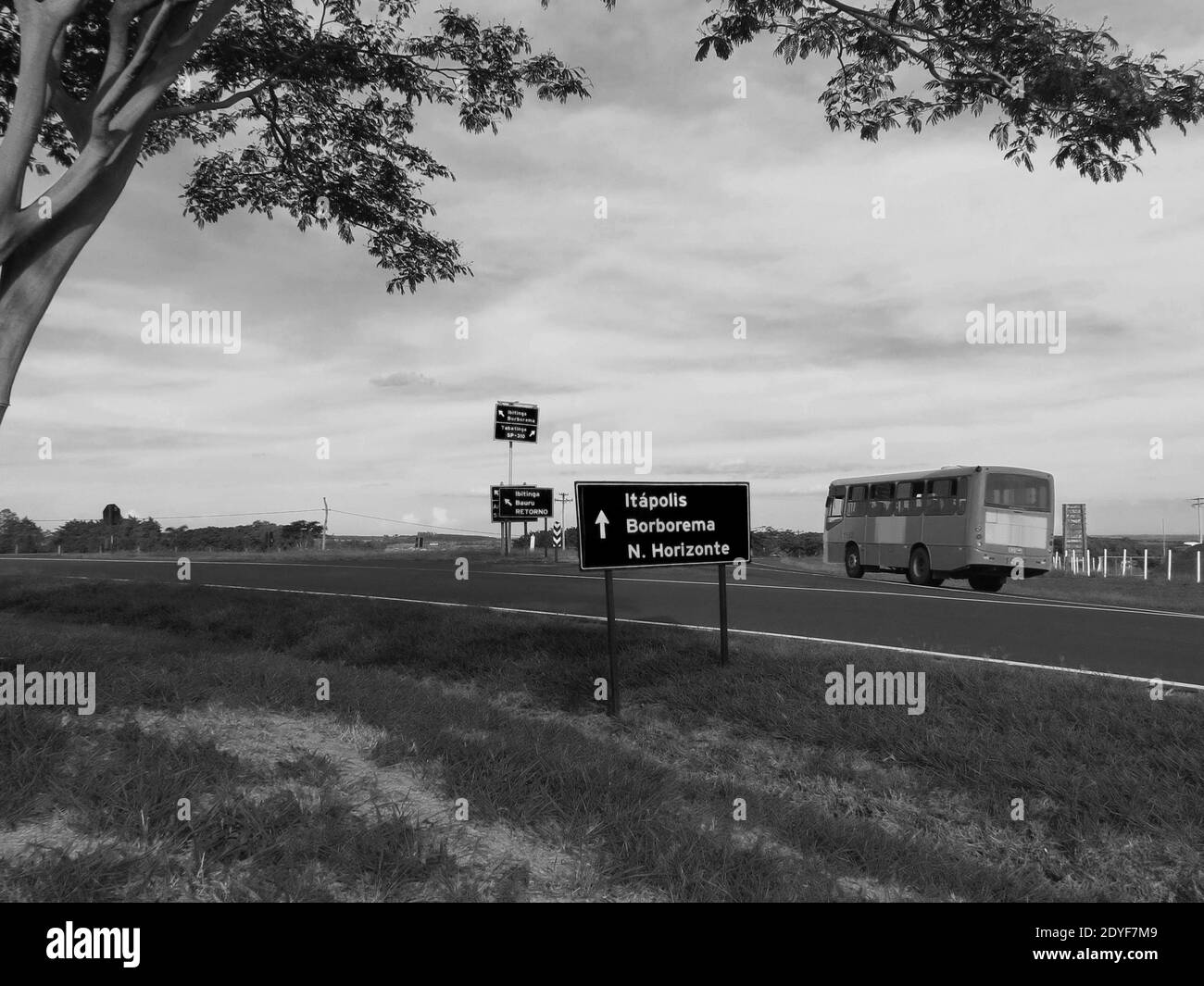 Bus vorbei an einem Straßenschild in der Landschaft von Brasilien [Schwarz-Weiß-Farben] Stockfoto