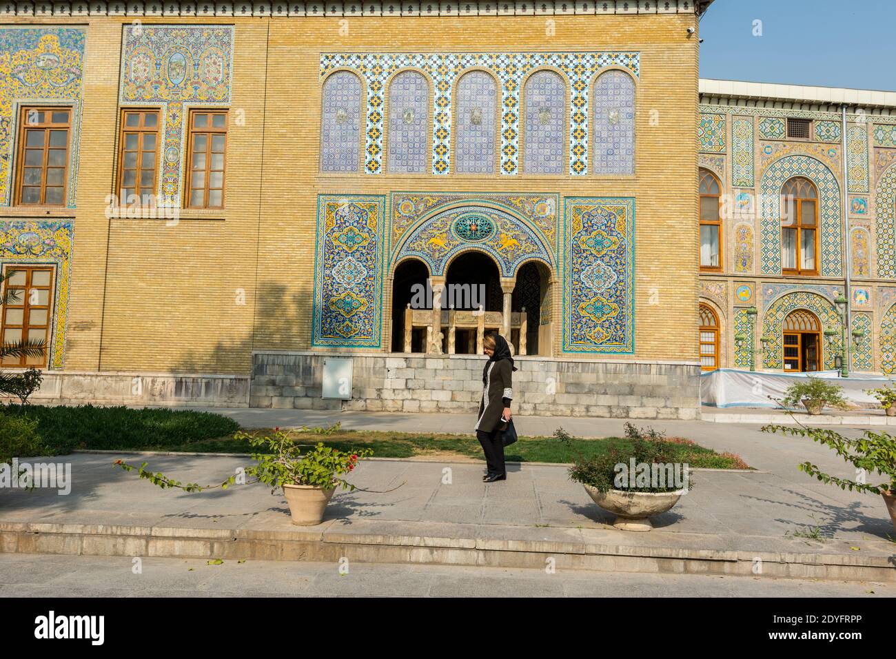 Eine iranische Touristin mit schwarzem Hijab, die an Karim Khani NOOK (Khalvat e Karim Khani) im Golestan-Palast, Teheran, Iran vorbeikommt Stockfoto