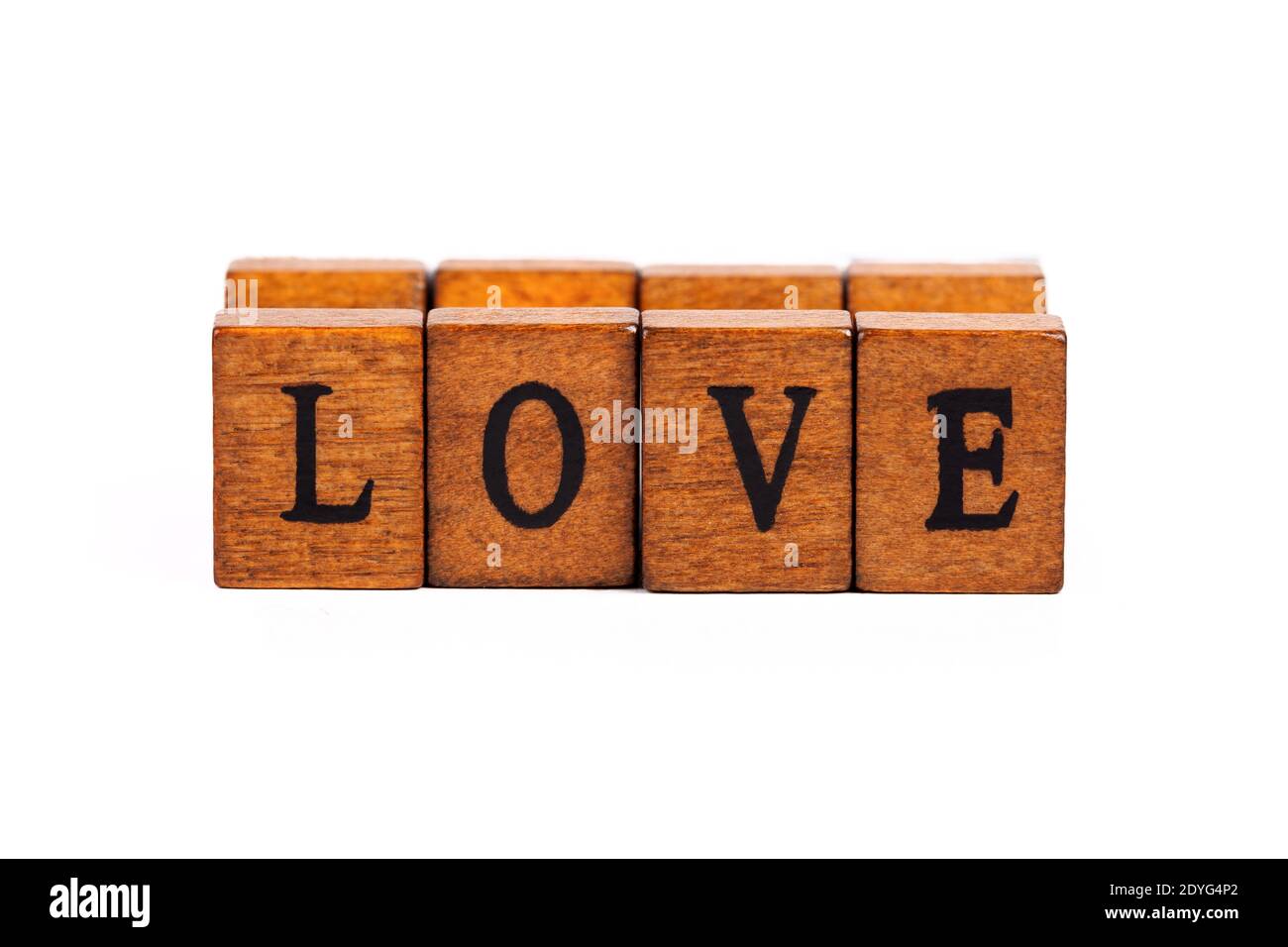 Wort LIEBE isoliert, Holzbuchstabe Gummi Stempel Schrift Nahaufnahme, auf weiß, ausgeschnitten. Einfaches Love Concept Textelement, Buchstaben aus nächster Nähe, Kopierraum, Retro Stockfoto