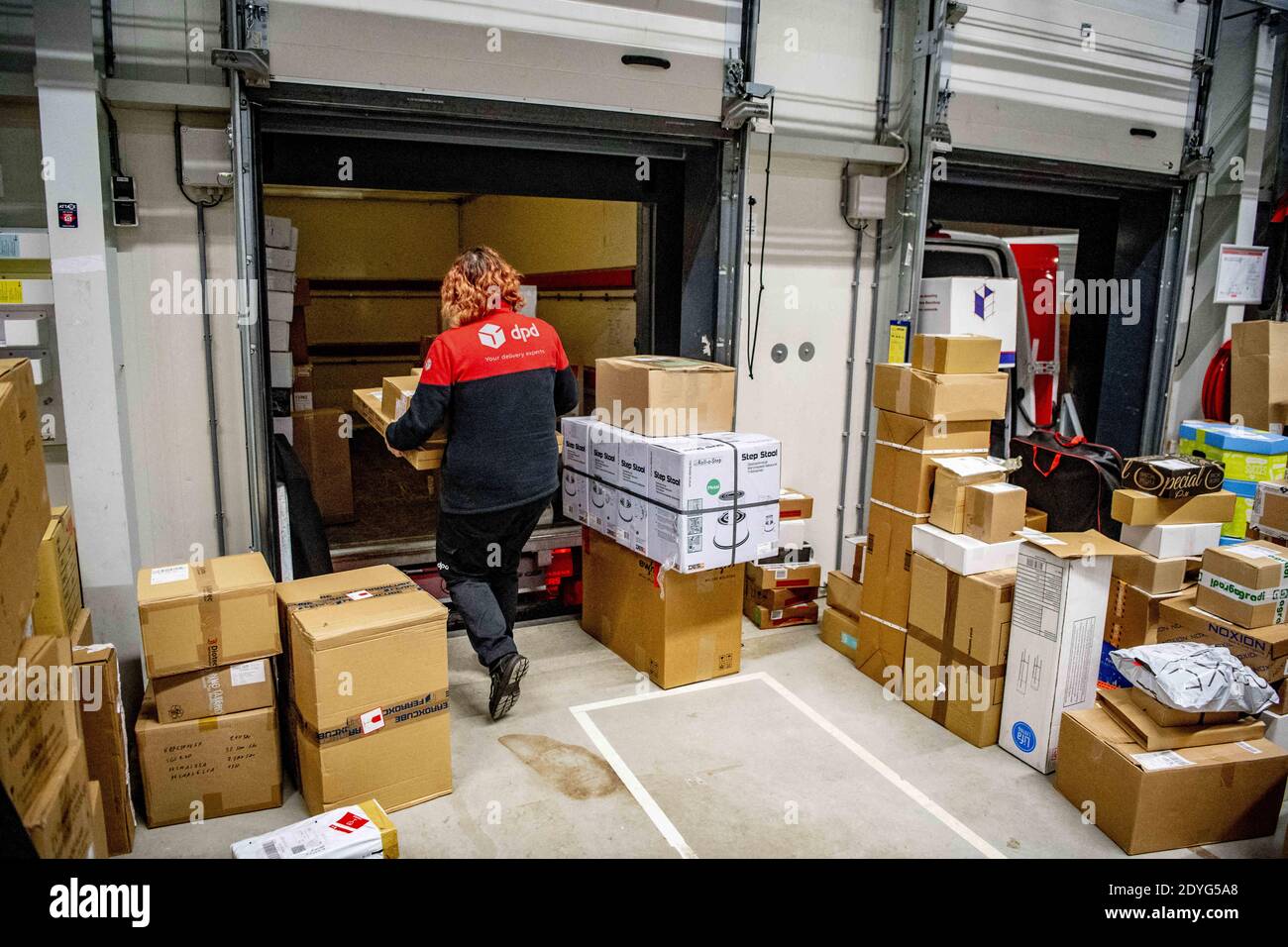 Zustellfirma DPD Paketsortierzentrum in Oirschot, Niederlande, am 24.  Dezember 2020. Mitarbeiter von DPD sortieren Pakete in der  Paketsortierzentrale. Dies ist eine der geschäftigsten Zeiten des Jahres im  Vorfeld von Weihnachten. Aufgrund der