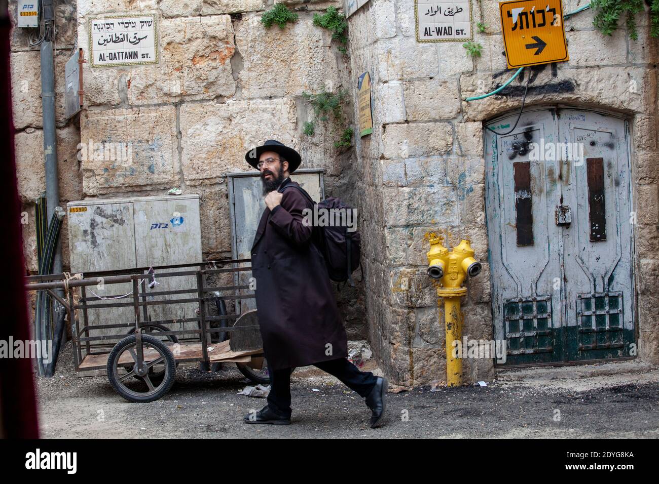 Orthodoxe Juden gehen entlang einer Straße in der Altstadt von Jerusalem Stadt im jüdischen Viertel während eines Regens, Israel Stockfoto