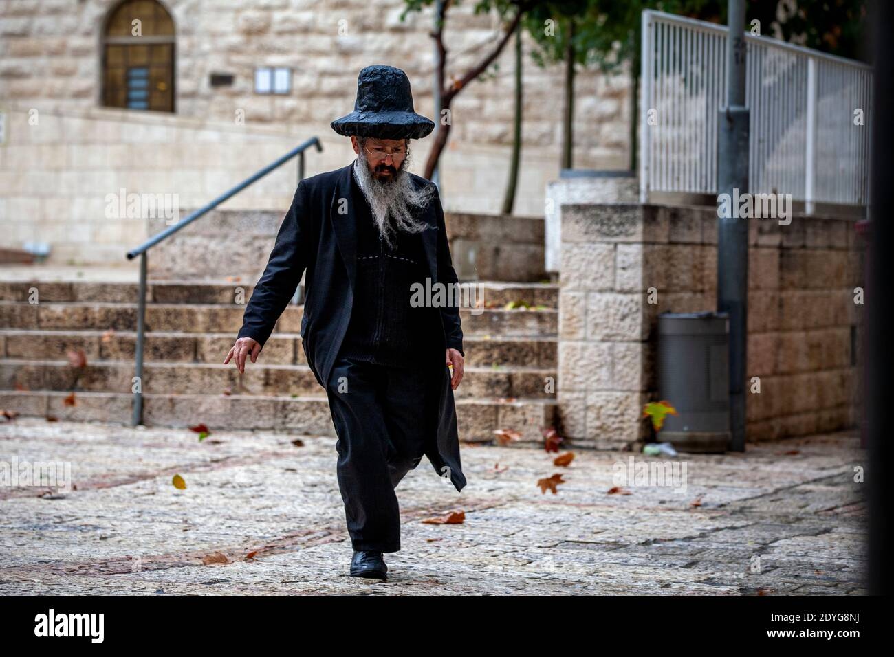 Orthodoxe Juden gehen entlang einer Straße in der Altstadt von Jerusalem Stadt im jüdischen Viertel während eines Regens, Israel Stockfoto
