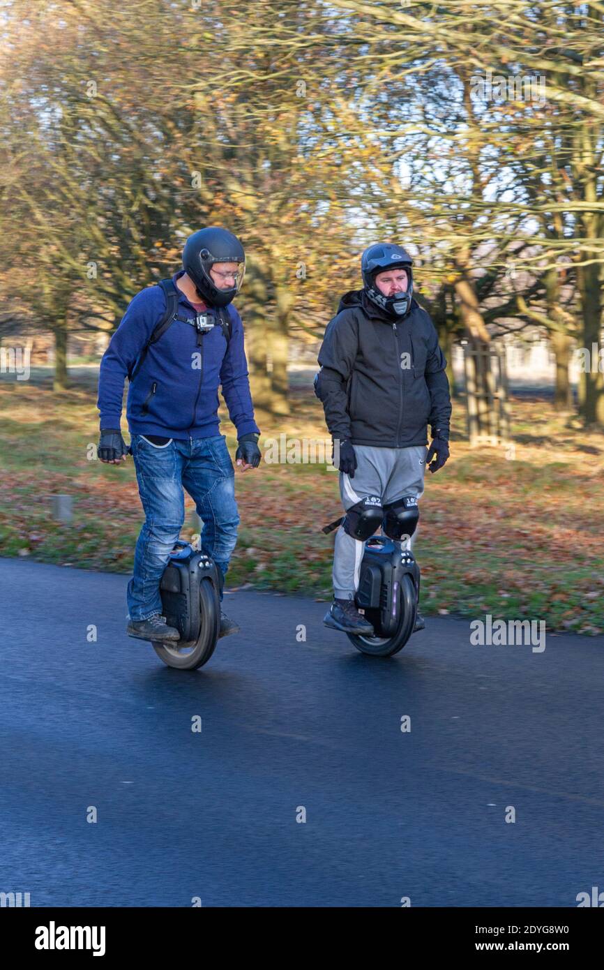 Zwei Männer auf elektrischen Einrädern (EUC) in Richmond Park, London, Großbritannien. Stockfoto