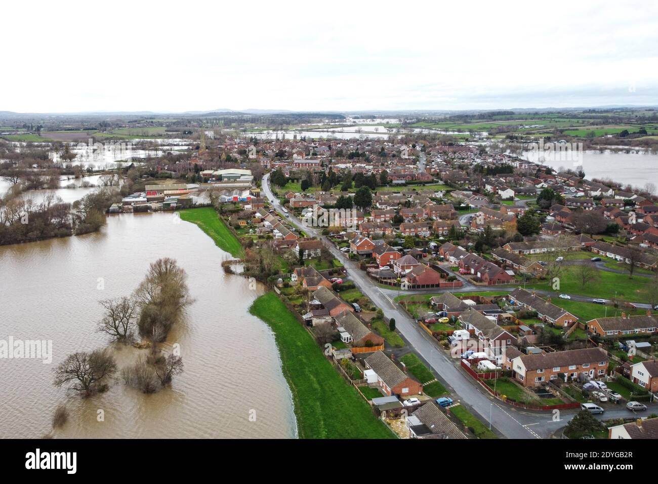 Upton upon Severn, Worcestershire, Großbritannien. Dezember 2020. Das kleine Dorf Upton upon Severn in Worcestershire wurde von Überschwemmungen umgeben, nachdem der Fluss Severn seine Ufer platzte. Mehrere Grundstücke sind durch eine kleine Grasbank geschützt, die riesige Wasserschwaden zurückhält. Ein Rugby-Platz wurde vollständig unter Wasser getaucht und Häuser haben Wasser in ihren Gärten, während Storm Bella ins Vereinigte Königreich reißt. PIC by Credit: Stop Press Media/Alamy Live News Stockfoto