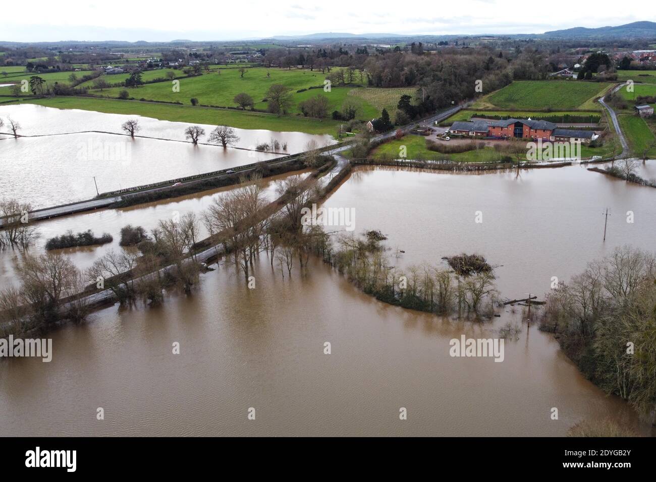 Upton upon Severn, Worcestershire, Großbritannien. Dezember 2020. Das kleine Dorf Upton upon Severn in Worcestershire wurde von Überschwemmungen umgeben, nachdem der Fluss Severn seine Ufer platzte. Mehrere Grundstücke sind durch eine kleine Grasbank geschützt, die riesige Wasserschwaden zurückhält. Ein Rugby-Platz wurde vollständig unter Wasser getaucht und Häuser haben Wasser in ihren Gärten, während Storm Bella ins Vereinigte Königreich reißt. PIC by Credit: Stop Press Media/Alamy Live News Stockfoto