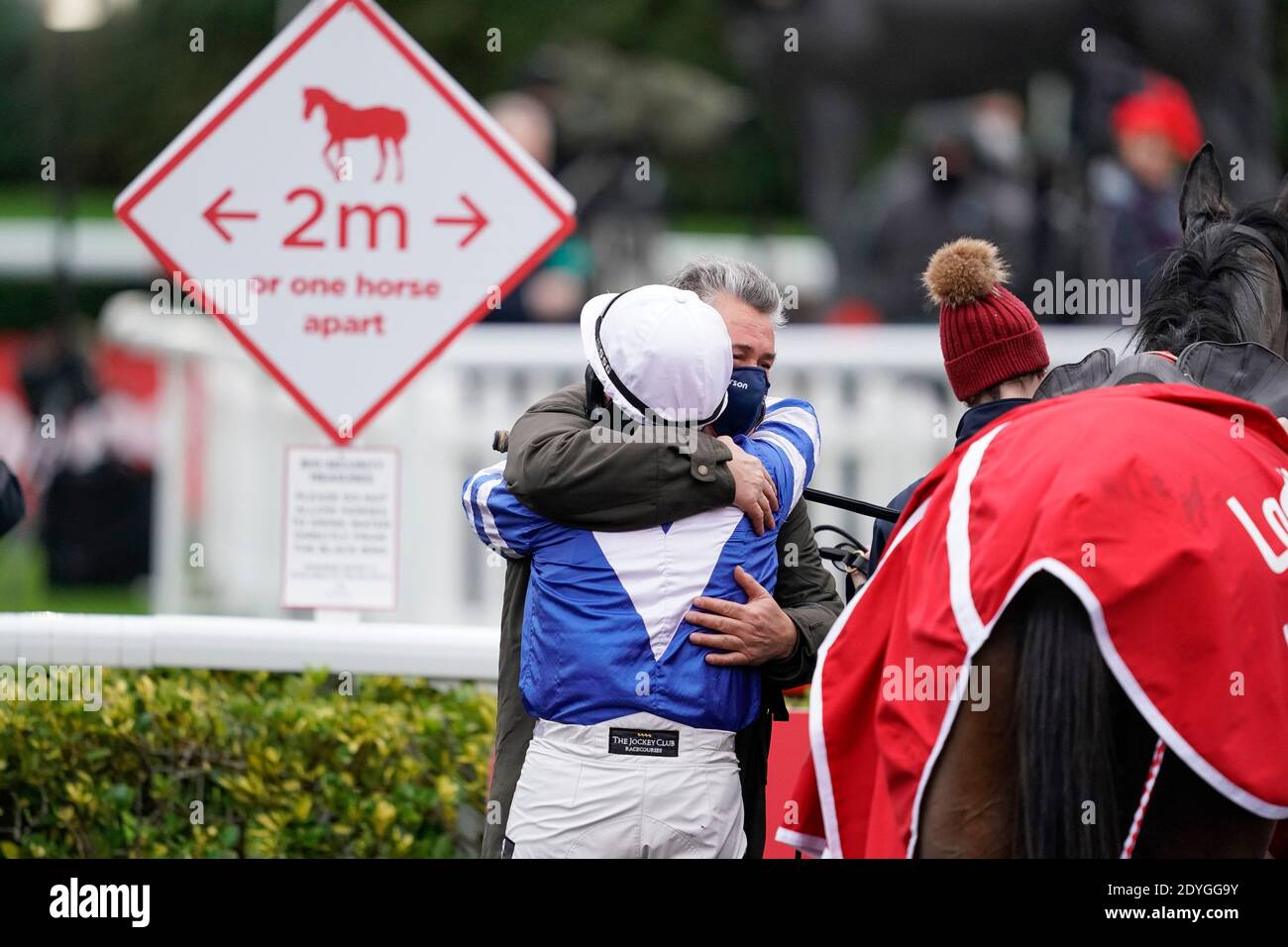 Bryony Frost wird von Trainer Paul Nicholls umarmt, nachdem er Frodon beim King George VI Chase Day des Ladbrokes Christmas Festival auf der Kempton Park Racecourse, Sunbury-on-Thames, zum Sieg gefahren hat. Stockfoto