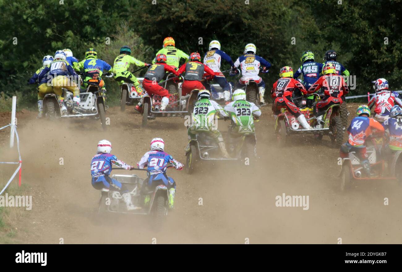 Große Gruppe von Moto-Cross-Outfits am Star der Ein Rennen mit Staub und Schmutz überall fliegen Stockfoto