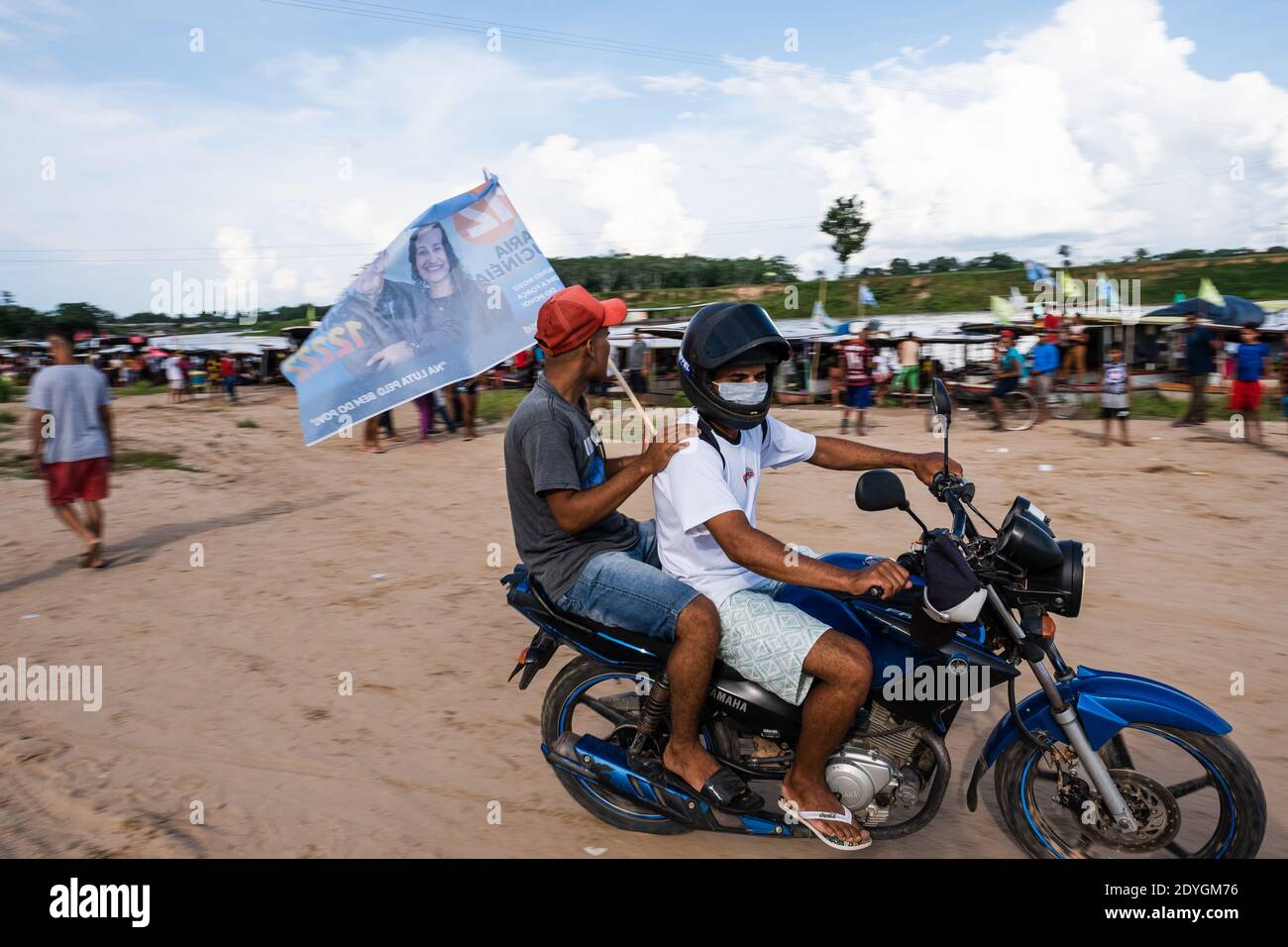 Ein Motorradfahrer und sein Sozius Passagierleinwand für eine politische Partei in Acre Staat, Brasilien. Stockfoto