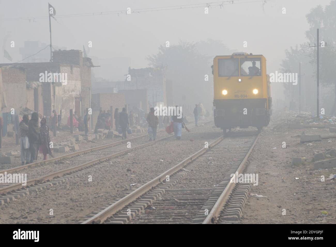 Pakistanische Pendler machen ihren Weg inmitten dichten Nebel auf ein Kalter Winter in Lahore Stockfoto