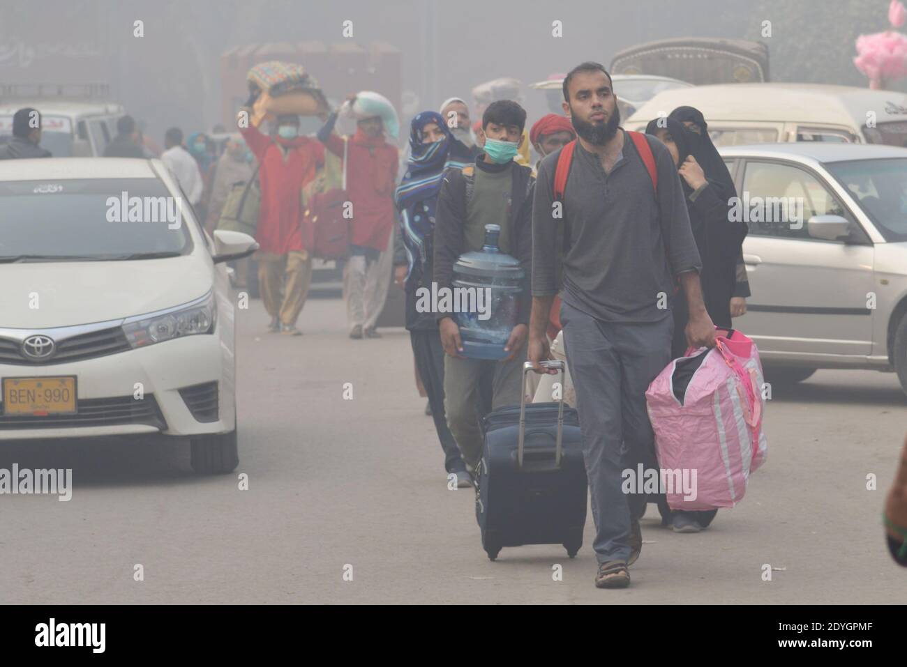 Pakistanische Pendler machen ihren Weg inmitten dichten Nebel auf ein Kalter Winter in Lahore Stockfoto