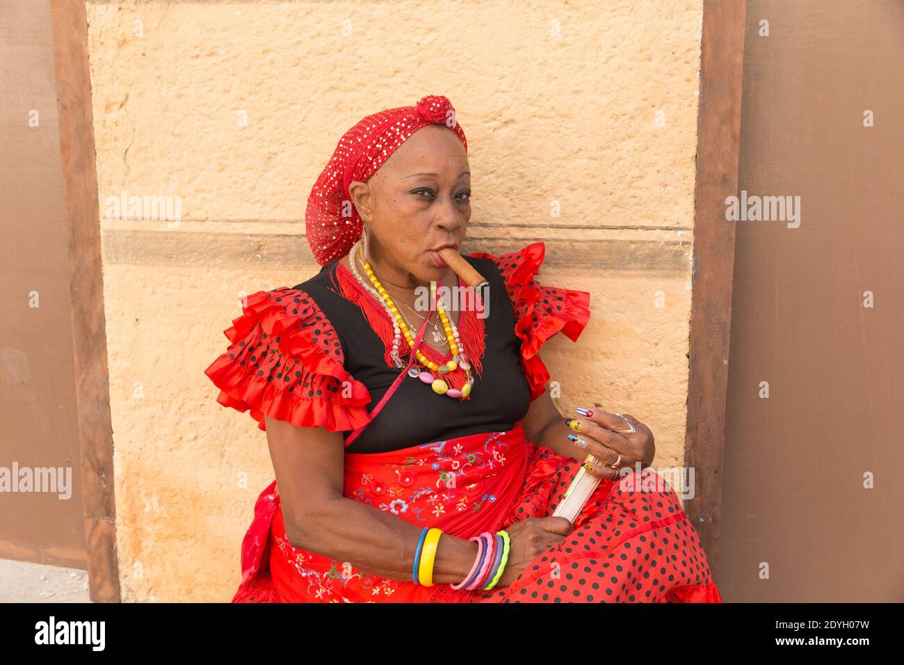 Dame in traditioneller Kleidung Rauchen EINER Zigarre in der Altstadt von Havanna Stockfoto