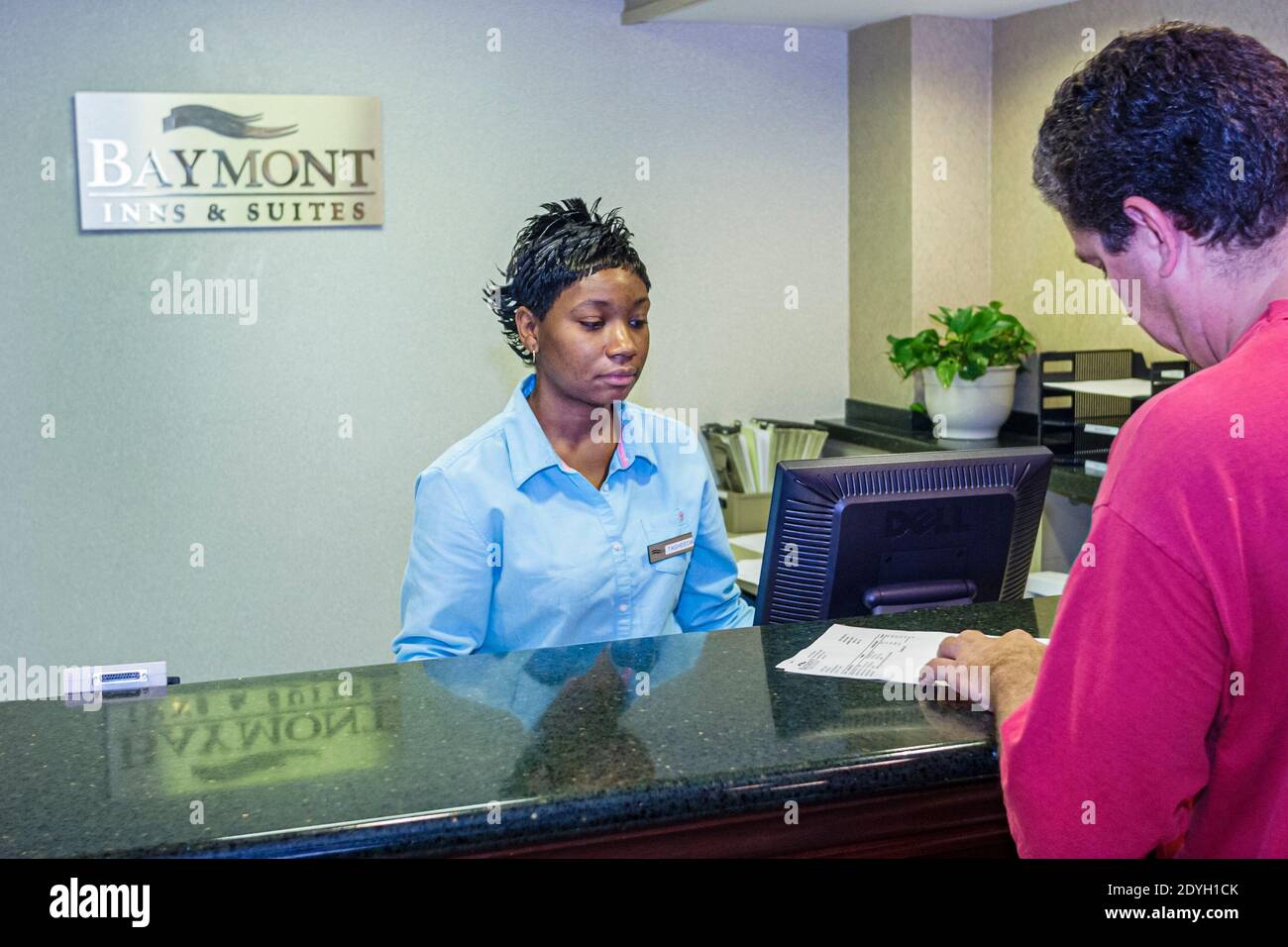 Birmingham Alabama, Baymont Inn & Suites, Hotellobby Schwarze Frau Angestellte an der Rezeption, Rezeptionist reserviert Mann männlicher Gast beim Check-in Stockfoto
