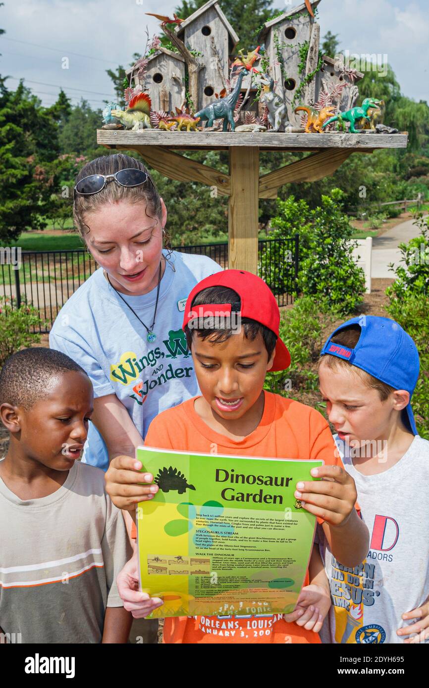 Huntsville Alabama, Botanischer Garten für Kinder im Freien, schwarzer Junge Jungen Führer Lehrer hilft erklären Dinosauriergarten, Stockfoto