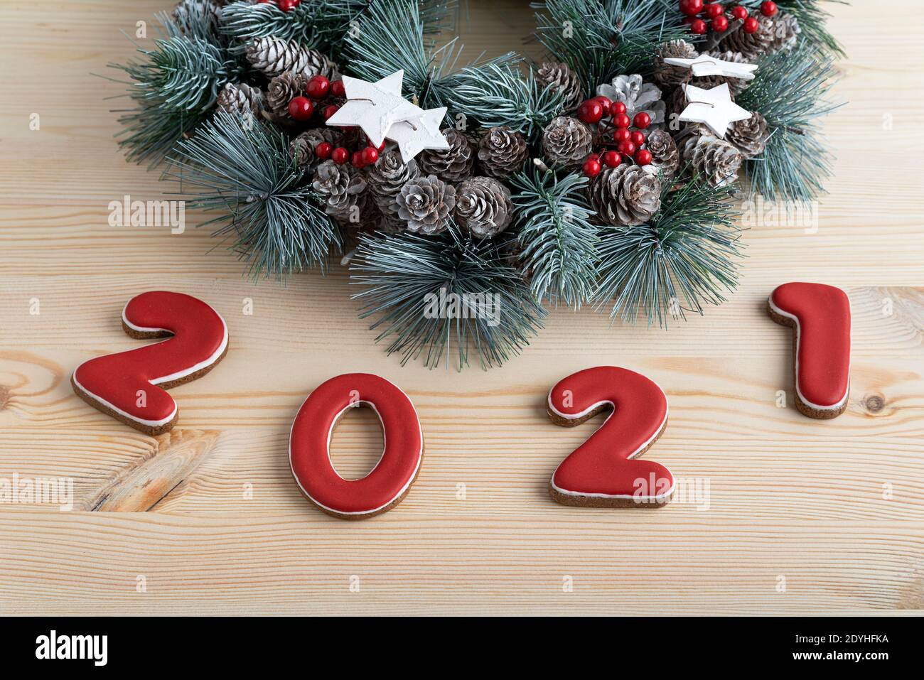 Weihnachtskranz und rote Nummer 2021 aus Lebkuchen. Frohe Weihnachten Hintergrund Stockfoto