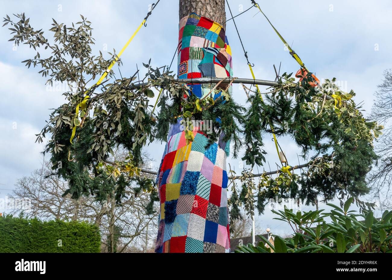 Natürliche weihnachtsdekorationen mit Stechpalme und Kiefer um einen Baum mit einer Decke aus gehäkelten Plätzen außerhalb St Mary's Church, Ash Vale, Großbritannien Stockfoto