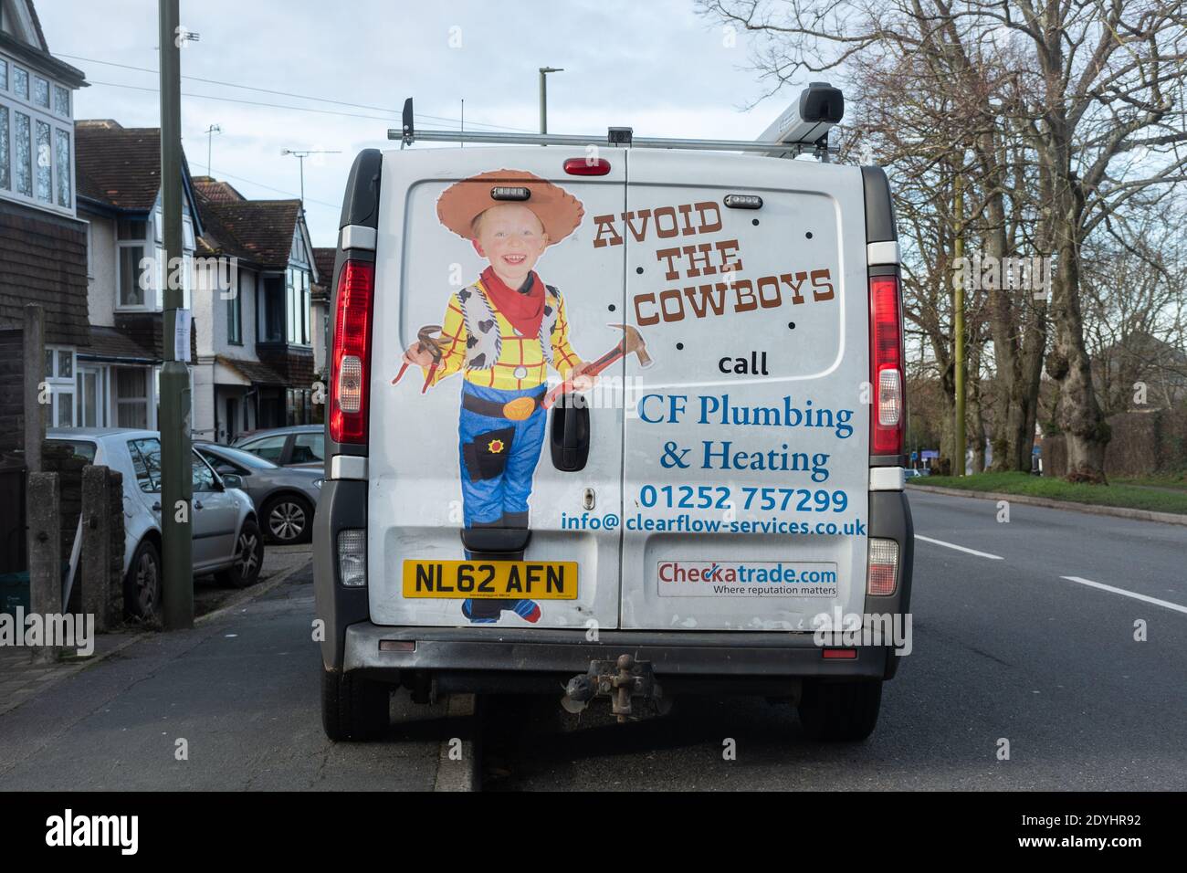 Weißer Klempner-Van mit Vermeiden der Cowboys auf der Rückseite gemalt, bezieht sich auf Cowboy-Bauherren und Handwerker. Stockfoto