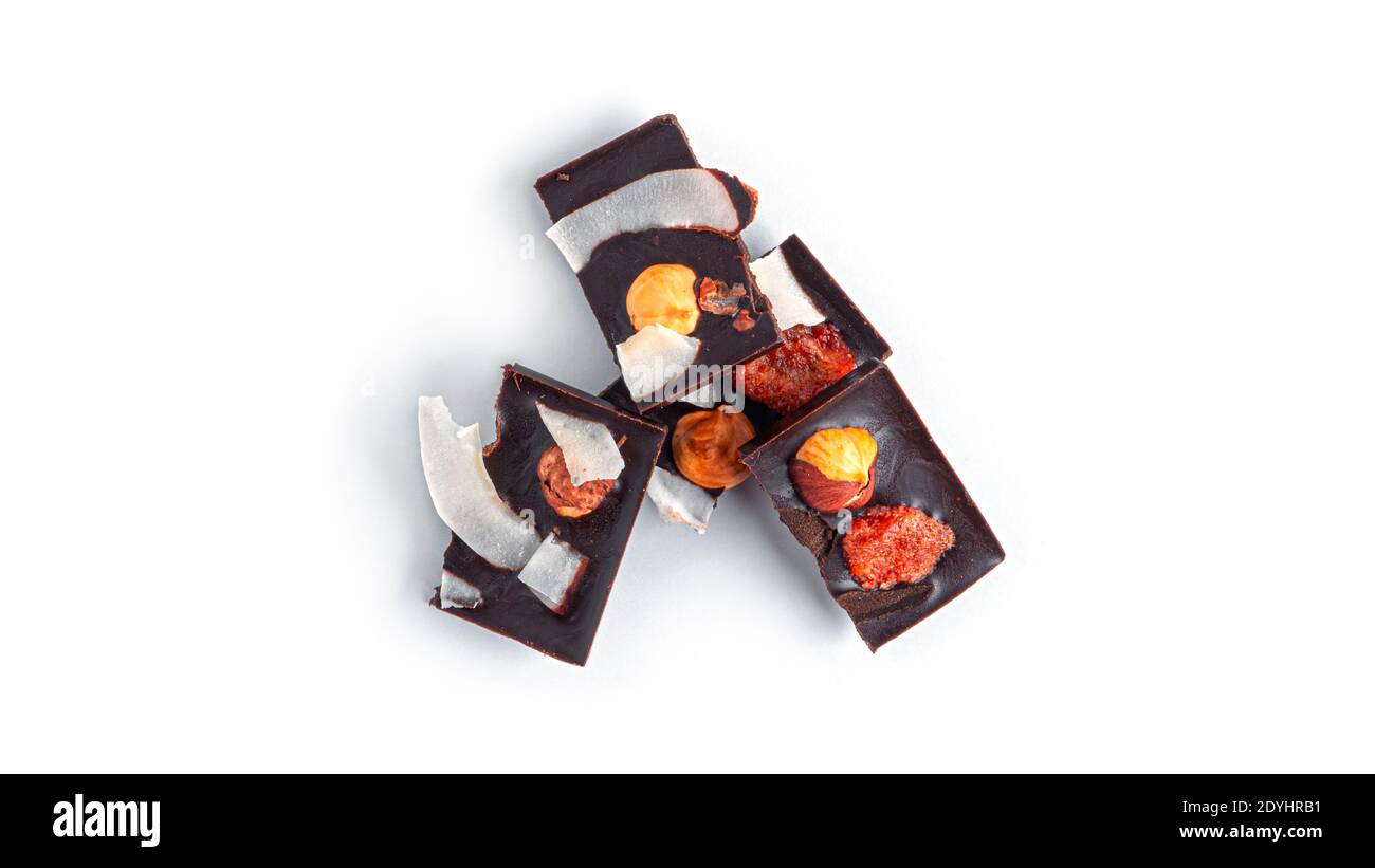 Rohe Schokolade mit getrockneten Früchten und Nüssen auf weißem Hintergrund. Hochwertige Fotos Stockfoto