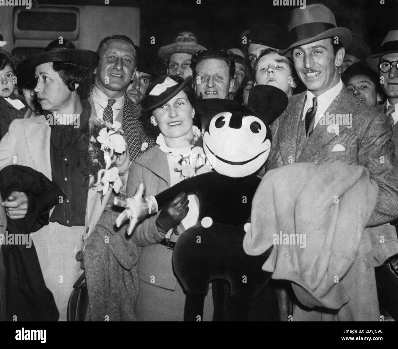 WALT DISNEY und seine Frau LILLIAN MARIE GRENZEN DISNEY auf Ankunft für einen Besuch in Großbritannien an der Paddington Station London Juni 1935 mit einem Mickey Mouse Plüschtier Stockfoto