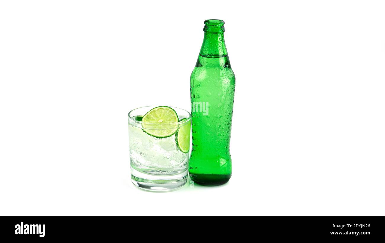 Grüne Flasche und transparentes Glas mit Limettenlimonade auf weißem Hintergrund. Hochwertige Fotos Stockfoto