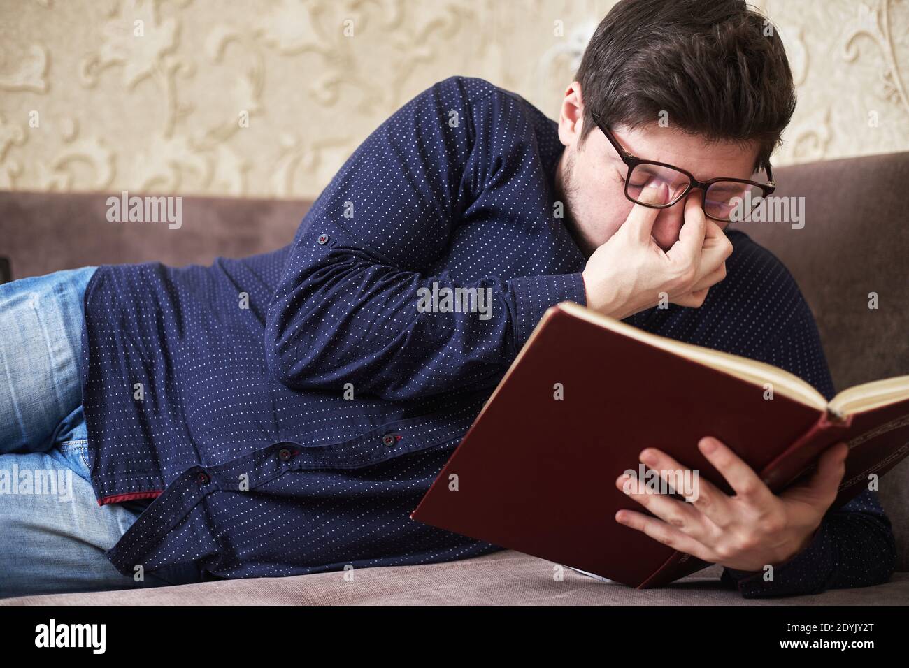 Konzept, kaukasischen Mann trägt Brille hat Wunde Augen beim Lesen eines Buches, Kopien des Raumes Stockfoto