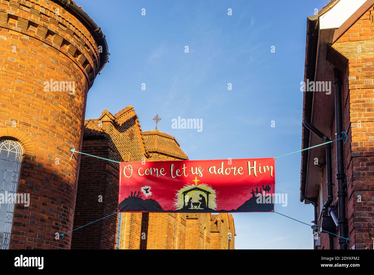 "O komm, lasst uns ihn anbeten" frommes festliches Weihnachtsbanner vor der St. Bonifatius katholischen Kirche in Shirley, Southampton, England, Großbritannien Stockfoto