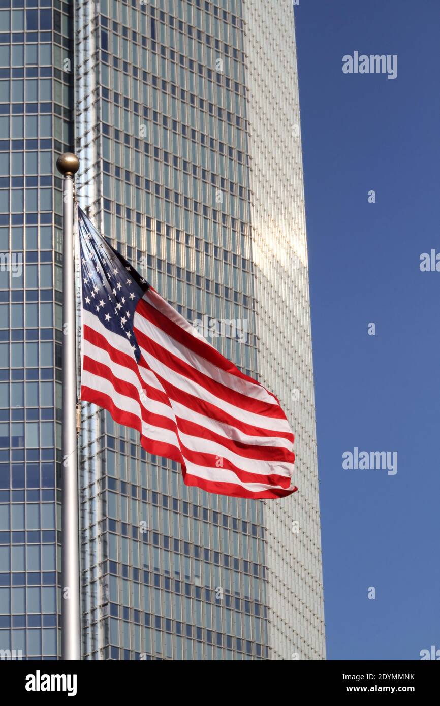 Neben einem hohen Wolkenkratzer in der Innenstadt von Oklahoma City winkt eine amerikanische Flagge. Stockfoto