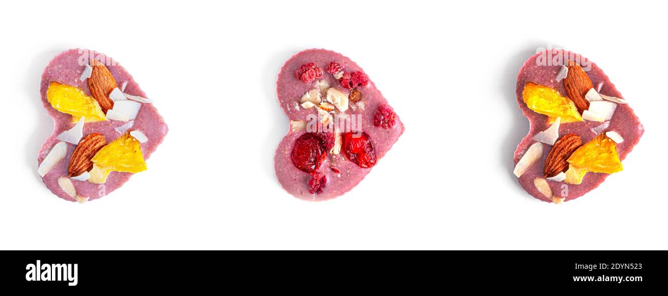 Rohe herzförmige Schokolade mit getrockneten Früchten und Nüssen auf weißem Hintergrund. Hochwertige Fotos Stockfoto