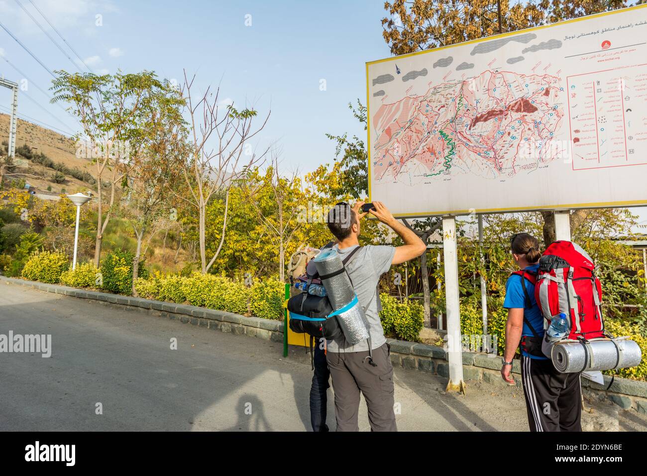 Ausländische Touristen, die auf der Karte zum Tochal Kletterroute zum Berg, Teheran, Iran. Tochal ist eine beliebte Erholungsregion für Teherans RE Stockfoto