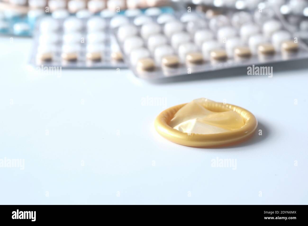 Nahaufnahme von Kondom und Geburt Kontrolle Pille auf weiß Stockfoto