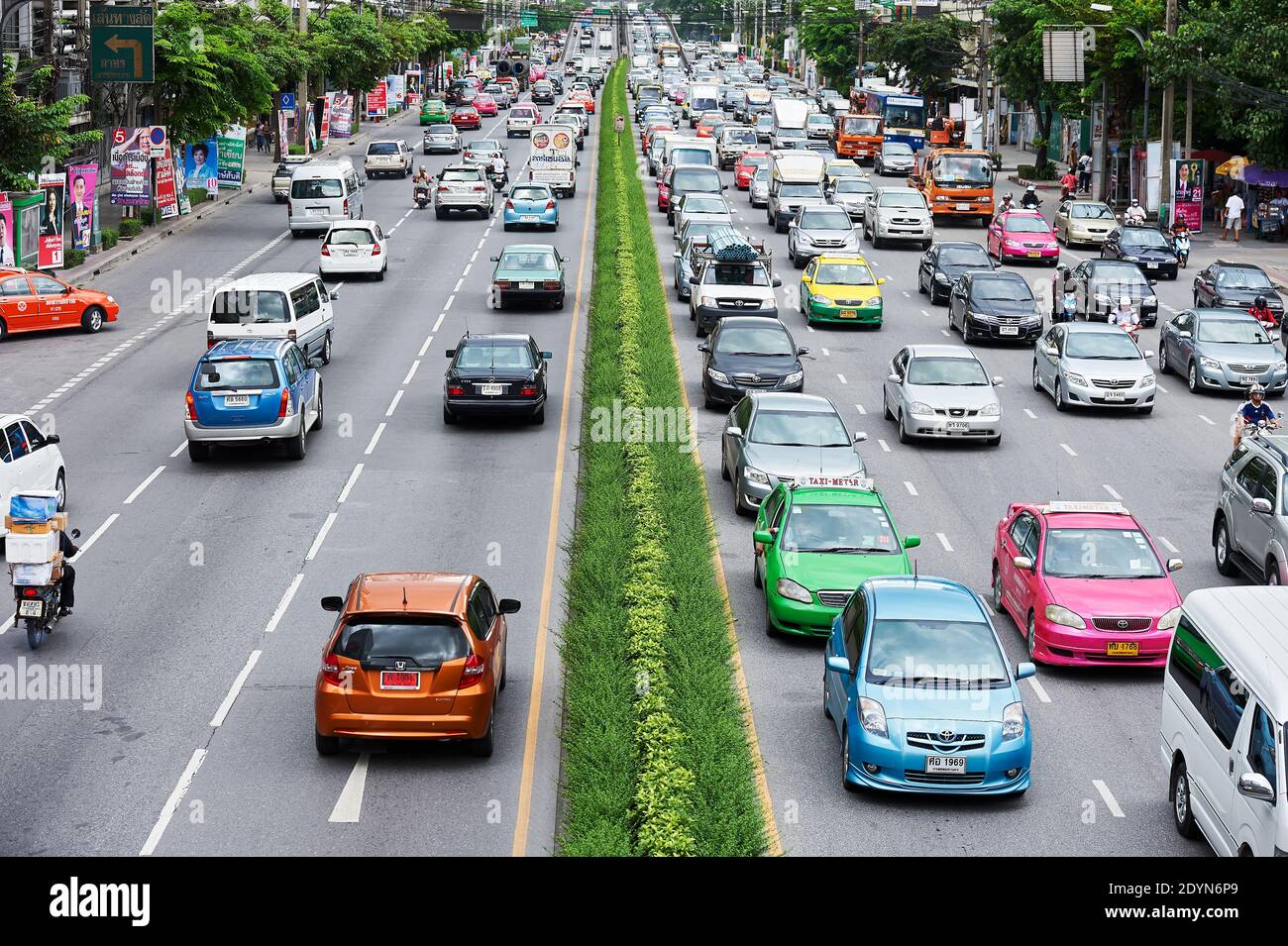 Bunte Autos, Taxis und Motorräder auf einem großen Rama Highway während der Hauptverkehrszeit in der Innenstadt grün Bangkok City, Asien Stockfoto