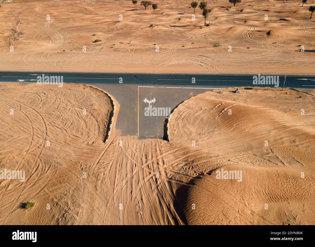 Leere Kreuzung mit Sandstraße treffen die Autobahn in der Vereinigte Arabische Emirate Wüste Luftbild Stockfoto