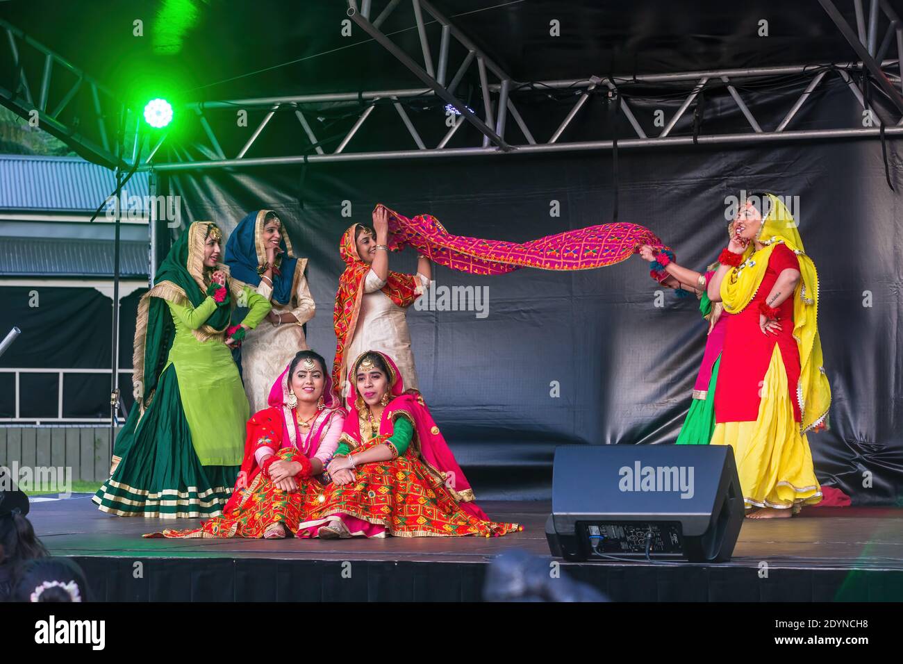 Eine Gruppe von indischen Frauen in bunten Saris Durchführung einer Schal Tanz auf der Bühne während Diwali Festival Feiern Stockfoto