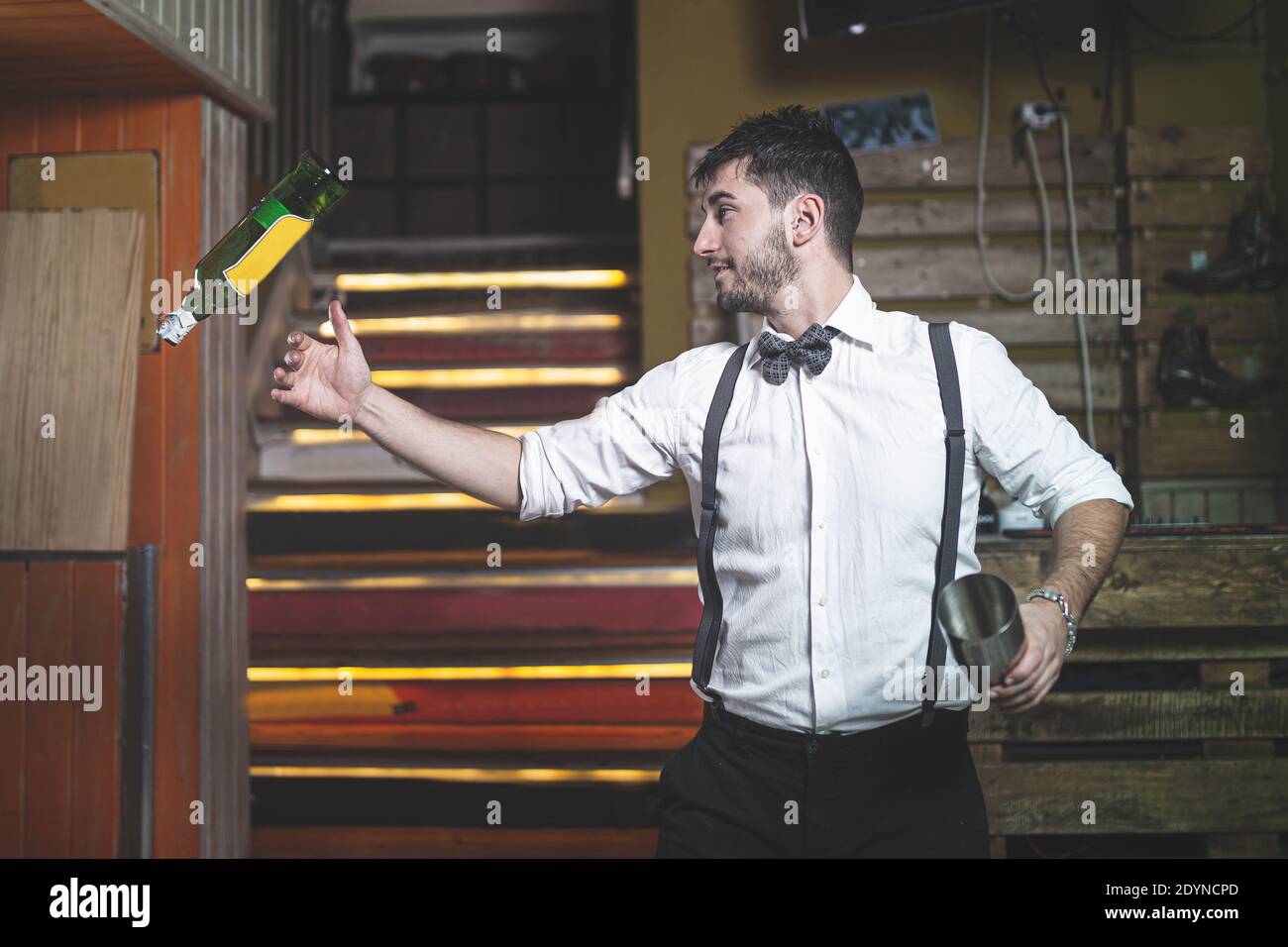 Experte Barkeeper mit Fliege werfen Flasche in der Luft. Stockfoto