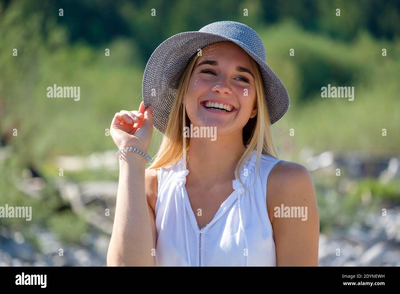 Portrait junge blonde Frau mit Sonnenhut im Sommer, Bayern, Deutschland Stockfoto
